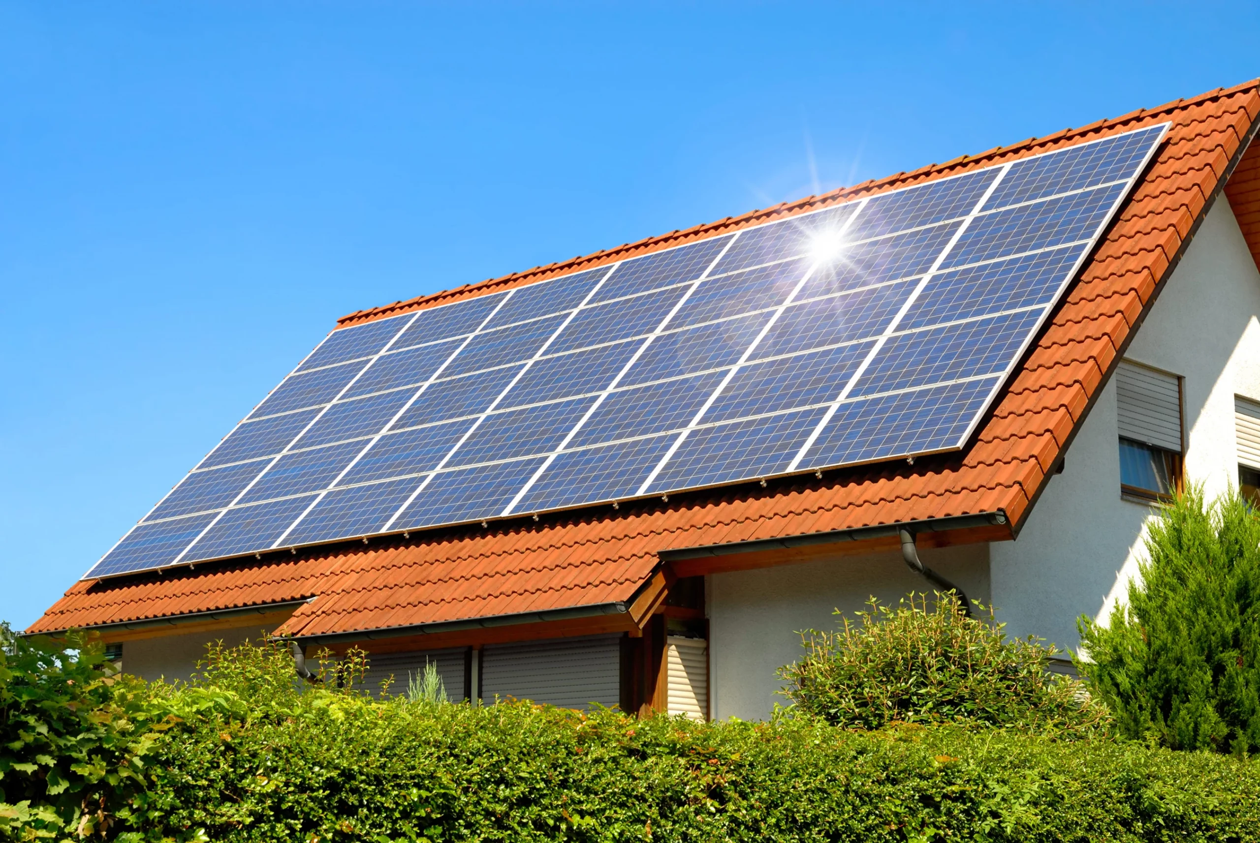 Solarmodule auf einem roten Dach eines Einfamilienhauses