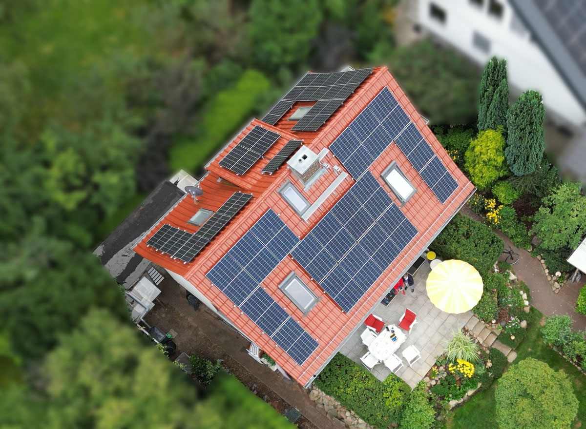 Drohnenansicht eines Einfamilienhauses mit einer Photovoltaikanlage auf dem Dach