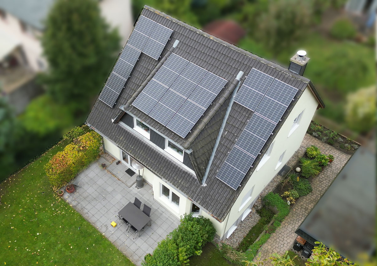 Einfamilienhaus in Konradshöhe mit der Drohne aus der Luft fotografiert. Auf dem Dach befindet sich eine Photovoltaikanlage.