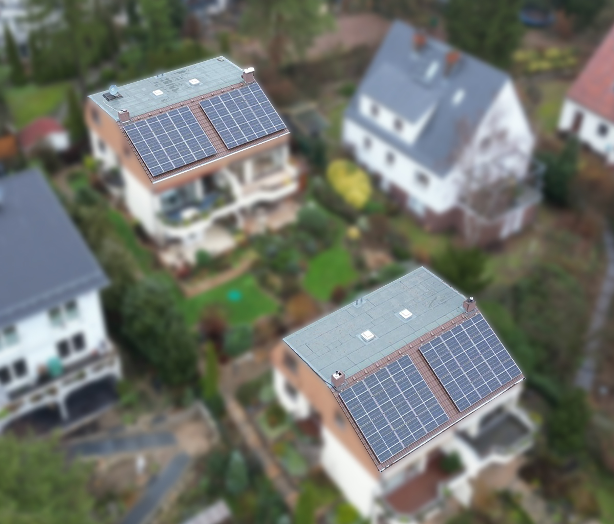 4 Mehrfamilienhäsuer aus der Luft fotografiert, 2 davon sind mit Solaranlagen auf den Dächern bestückt.